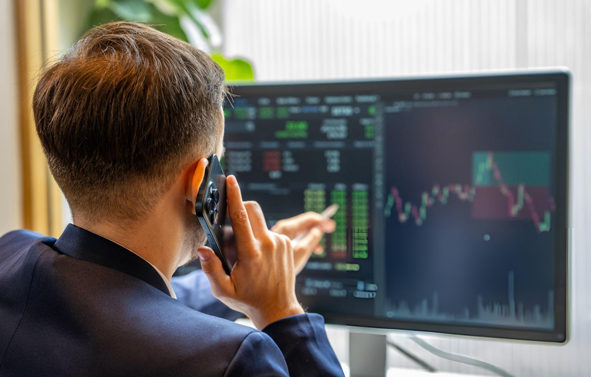 Portfolio manager reviewing market data on a trading desk
